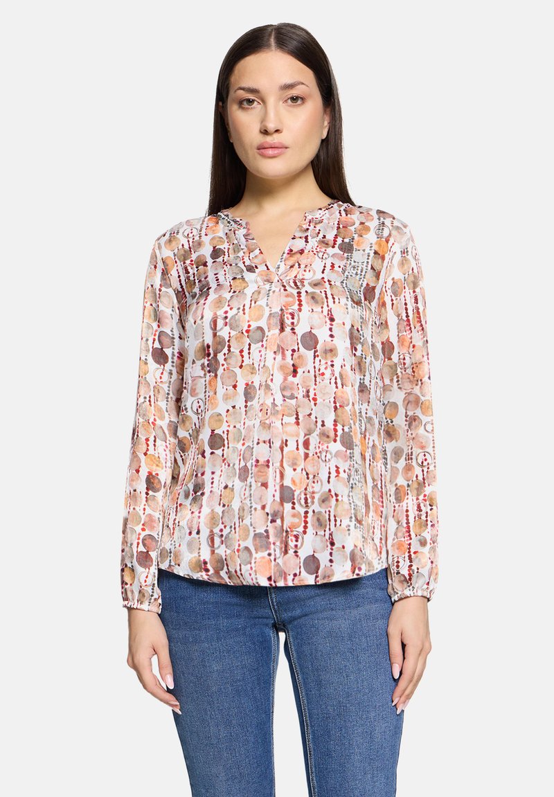 Doorzichtige blouse met lange mouwen en een v-hals, versierd met een kleurrijk, cirkelvormig patroon in tinten bruin, perzik en room. Geweven stof.