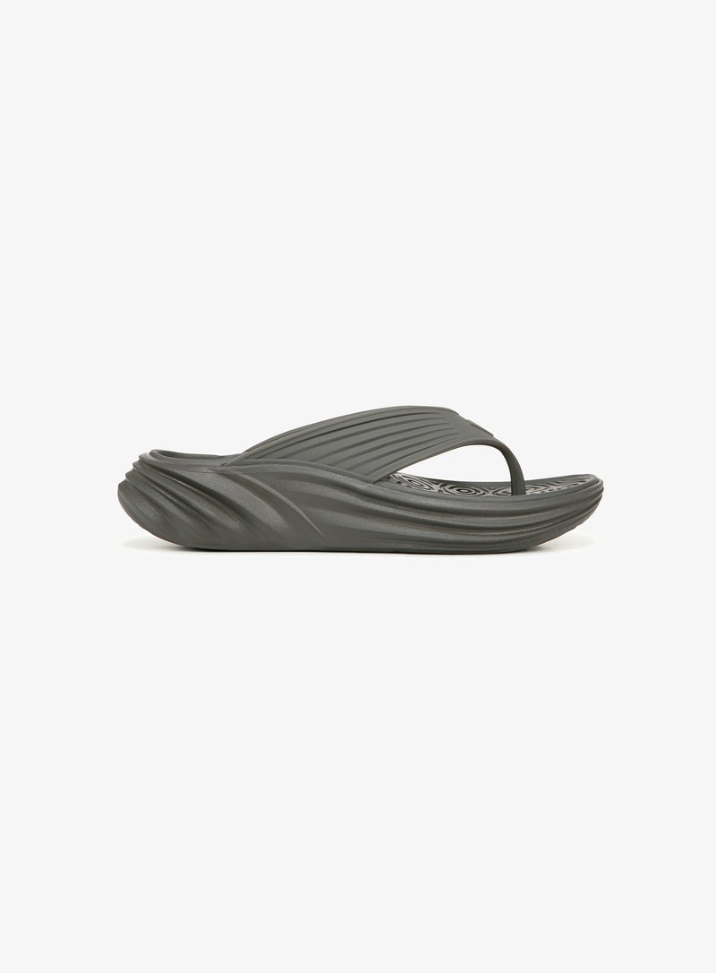 Donkergrijze flip-flop van getextureerd PVC-materiaal, met een gebogen zool en horizontale ribbels. Dunne band over de voet met een gevoerde binnenzool.