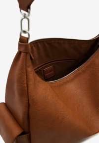 Borsa a mano in pelle marrone con superficie texturizzata, tracolla regolabile e scomparto interno con zip e tasca aggiuntiva.