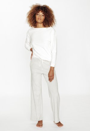 Maglietta bianca a maniche lunghe abbinata a pantaloni a gamba larga a righe chiare con cintura elastica regolabile. Tessuto morbido e vestibilità comoda.