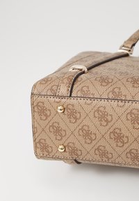 Bruine handtas met patroon, voorzien van een textuurafwerking, gouden hardwareaccenten en afgeronde hoeken. Inclusief vier metalen studs aan de onderkant.