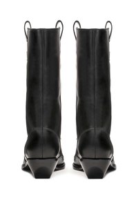 Botas de cuero negro hasta la rodilla con punta afilada y tacón cónico. Las características incluyen tiradores en la parte trasera y costuras verticales a lo largo del caño.
