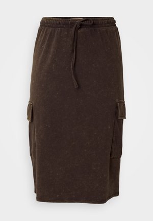 Brūna kokvilnas maisījuma midi svārki ar elastīgu jostasvīru un aukliņu. Sānu kabatas un brīva piegriezuma forma. Smalka tekstūra.