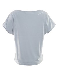 Camiseta gris claro de manga corta con un corte holgado, escote redondo y tejido suave. Presenta un sutil logo bordado en la parte posterior.