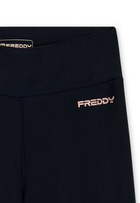 Leggings neri a vita alta con dettaglio della cucitura frontale e piccolo logo "FREDDY" di colore rosa chiaro sulla parte superiore dell'anca sinistra.