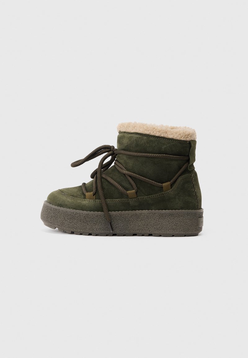 Stivale verde in suede con un morbido colletto in pelliccia beige, lacci rotondi e suola in gomma grigia texturizzata. Presenta dettagli cuciti sui lati.