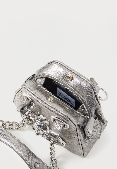 Μικρό ασημένιο τσαντάκι χιαστί με υφή φολιδών φιδιού, αλυσίδα ως λουρί, μερικώς ανοιχτό φερμουάρ σε διαμέρισμα και λεπτομέρεια κλεισίματος με περιστροφικό μηχανισμό.