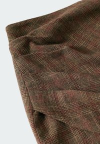 Tissu à carreaux brun et rouge, tissage texturé avec des épaisseurs de fil variées, tombé souple, légère brillance, présentant un motif en grille complexe.