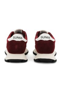 Sneakers in suede rosso con un tallone bianco che presenta il testo nero "SUN68". La fattura robusta della suola intermedia bianca e la suola in gomma nera offrono un contrasto.