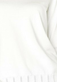 Hvid strikket sweater med en glat tekstur, der har en markant ribbede kant nederst og subtile syninger.