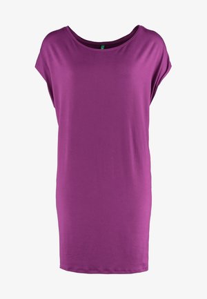 Paarse korte mouwen jurk met een losse pasvorm, gemaakt van zacht stof; gecombineerd met zwarte panty's en enkellaarsjes, een metallic clutch vasthoudend.