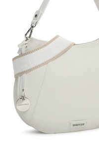 White leather handbag with a curved shape, featuring a textured finish, a wide fabric strap in white with beige accents, and a silver logo tag.