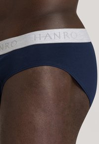 Slip in cotone blu navy con morbido elastico grigio con logo "HANRO", progettato per il comfort e una silhouette aderente.