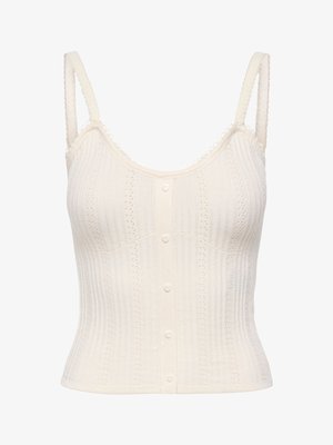 Top court sans manches en tricot couleur crème avec fines bretelles et boutons en forme de cœur sur le devant.