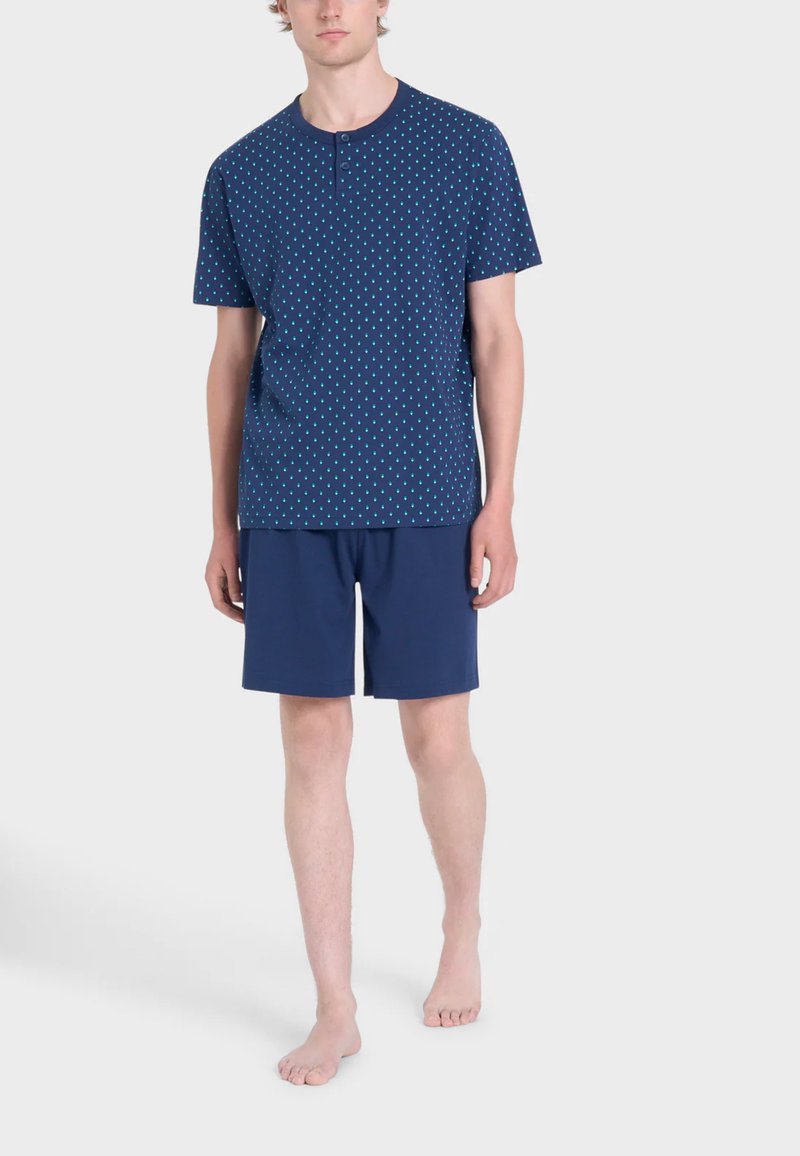 Camicia a maniche corte blu navale con pois turchesi e collo a giro, abbinata a pantaloni corti blu navale; leggero, vestibilità casual.