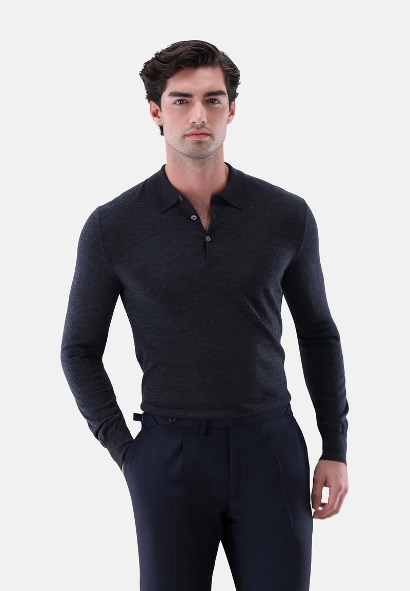 Dunkelgraues langärmeliges Polohemd aus weichem Material, mit Kragen und einer Knopfleiste mit drei Knöpfen, kombiniert mit maßgeschneiderten navyblauen Hosen.