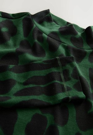 Zelená a černá žebrovaná tkanina s leopardím vzorem, kulatým výstřihem a kontrastním černým lemem podél okrajů.