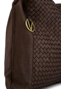 Brązowa, pleciona skórzana torebka z gładką stroną, ozdobiona złotym elementem metalowym. Teksturowany wzór dodaje głębi ogólnemu projektowi.
