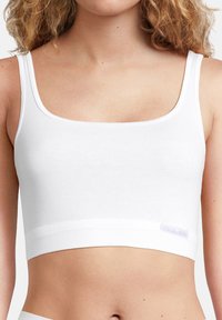 Weißes Baumwoll-Crop-Top mit quadratischem Ausschnitt, breiten Trägern und einem weichen elastischen Bund am Saum. Verfügt über ein kleines Logotag an der Seite.
