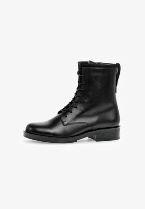 Bottines noires en cuir à lacets avec un bout arrondi, texture lisse et un petit talon empilé. Elles possèdent une languette à l'arrière.