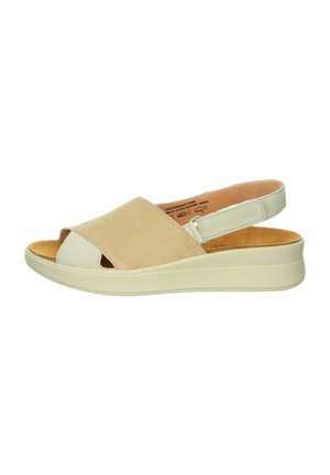 Beige and cream open-toe sandals with a suede upper, adjustable strap, and a textured rubber sole. Features a low platform design.