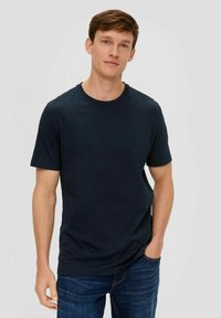 Marineblaue Baumwoll-T-Shirt mit Rundhalsausschnitt, kurzen Ärmeln und lässiger Passform, kombiniert mit blauen Jeans. Keine Muster oder Verzierungen.