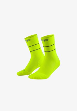 Neon yellow athletic socks with black horizontal stripes, featuring a ribbed cuff and a smooth, textured surface for comfort.
