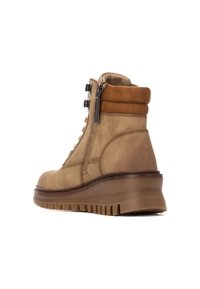 Botín de tobillo de cuero marrón claro con un acabado texturizado, que presenta una cremallera lateral, un cordón en la parte delantera y una suela de goma gruesa y estriada.