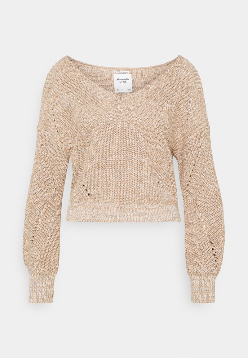 Pull en tricot court de couleur beige clair. Présente un décolleté en V profond, des manches larges et des détails en dentelle le long des coutures. Texture douce.