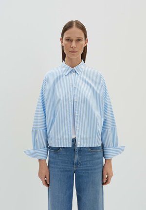 Blauw-wit gestreepte shirt met een kraag, knoopsluiting en brede mouwen met een manchetontwerp. Draagt hij met blauwe denim jeans.