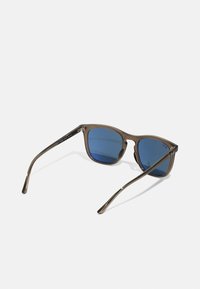 Sunglasses med brune plastikkrammer, blå tonede linser, firkantet form, metallakenter på tempelene og slanke buer.