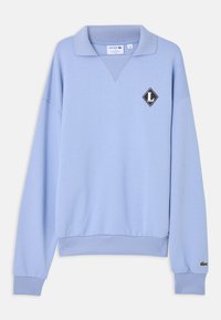 Pull bleu clair à manches longues avec poignets et ourlet côtelés, col ouvert et écussons au logo Lacoste sur la poitrine et la manche.