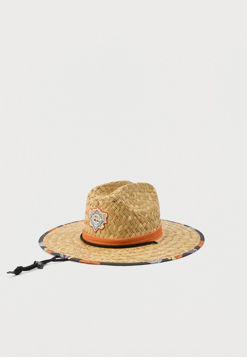 Καπέλο από ψάθα με φαρδύ γείσο, πορτοκαλί ταινία, μαύρο λουράκι στο πιγούνι, διακόσμηση με λουλούδια στην άκρη και ετικέτα με κρανίο και σταυρωτά οστά και το κείμενο "Quiksilver".