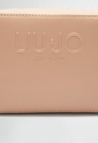 Portefeuille texturé couleur pêche avec logo embossé "LIU·JO MILANO". Doté de coutures lisses et d'une forme rectangulaire compacte.