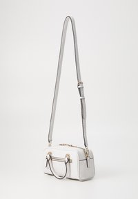 Borsa strutturata bianca con superficie testurizzata, manici doppi, tracolla regolabile e dettagli in hardware color oro.