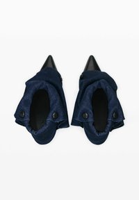 Mornarske traper cipele s ukaznim prstima, s naboranom tkaninom i crnim gumbima, uz glatku crnu unutrašnjost i elegantan siluetu.