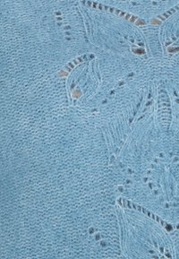 Tessuto lavorato a maglia blu chiaro con un delicato motivo a foglie. Texture morbida con punti visibili e sottili variazioni di colore.