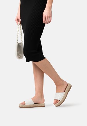 Sandalias blancas sin hebillas con textura acolchada, que cuentan con una suela de plataforma de yute tejido natural y una base de goma tostada.