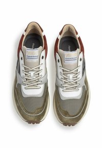 Sneakers con un mix di materiali: suede verde oliva, pelle bianca e mesh grigio. Presentano una forma arrotondata e una suola marrone a contrasto.