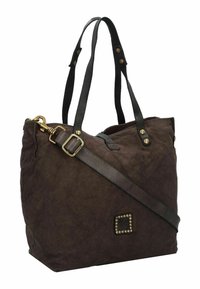 Bolso tote marrón oscuro hecho de tela texturizada, con asas de cuero negro, acentos de hardware dorado y un detalle cuadrado con tachuelas.