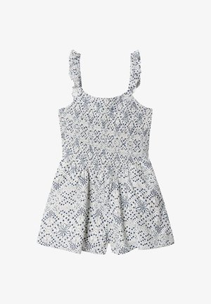 Mono blanco sin mangas con estampado floral geométrico azul, tirantes con volantes, cuerpo fruncido y parte inferior de pantalones cortos sueltos.