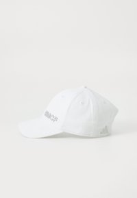 White baseball cap made of cotton with embroidered "RMCF" logo on the front and three stripes logo on the side. Curved brim design.