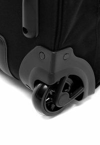 Valigia nera con ruote, caratterizzata da un corpo in tessuto resistente, protezione rinforzata agli angoli e un design delle ruote nere che scivolano senza problemi.