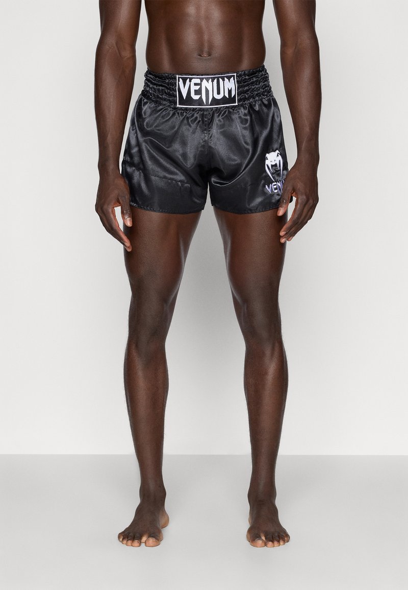 Pantalones cortos deportivos de satén negro con cintura elástica, con la marca "Venum" en blanco en la parte frontal. Textura suave y corte ajustado.