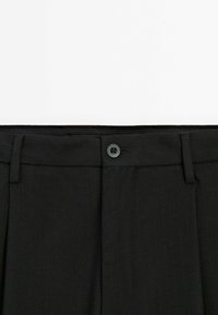 Black tailored trousers with vertical pinstripes, featuring a front button closure, belt loops, and two side pockets. Smooth fabric texture.