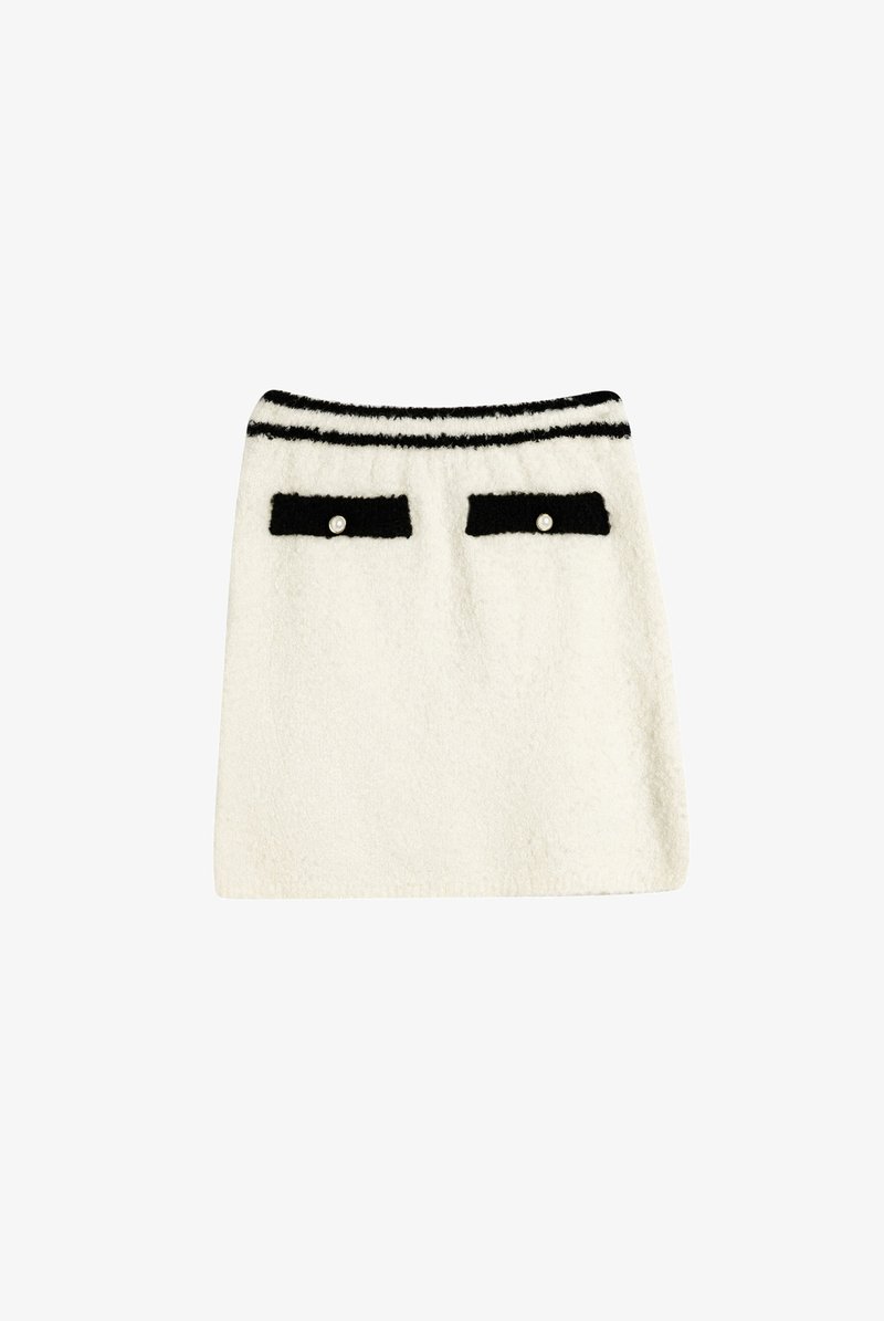 Falda blanca de lana con textura suave, acentos de bolsillo negros y una cinturilla a rayas. Presenta dos pequeños bolsillos con botones similares a perlas.