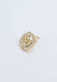 Boucle d'oreille en ton doré avec un design en forme de vagues, comportant une découpe centrale et entourée de strass transparents. Texture métallique lisse.