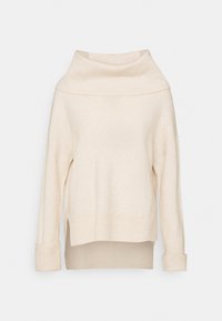 Krämfärgad stickad tröja med polokrage, vida ärmar, ribbade detaljer vid fållen och ärmsluten, samt en något oversized passform.