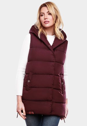 Vest pe timp rece de culoare burgundy, cu glugă, butoni cu clapă și două buzunare laterale. Material texturat cu un design matlasat. Purtați peste un pulover alb.