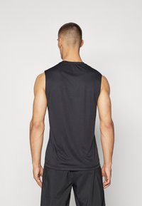 Top sportiv fără mâneci, de culoare neagră, realizat dintr-un material neted și ușor, având un guler rotund și detalii de design minime, vizibil din spate.